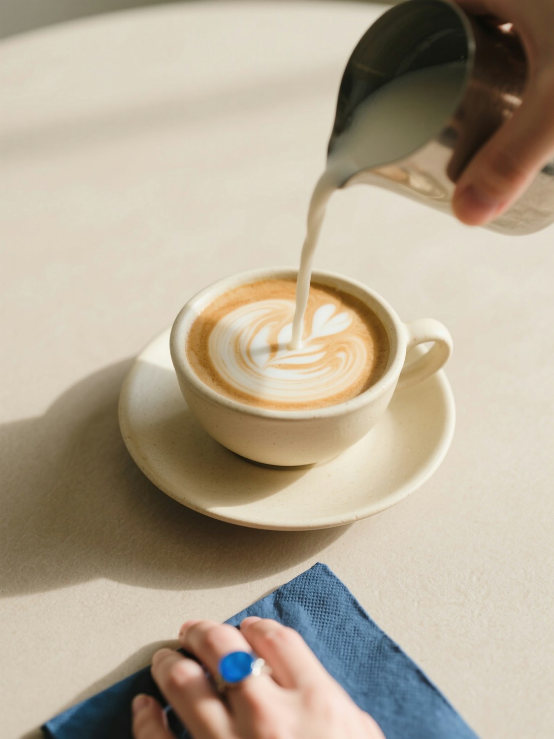 Barista pouring latte art into a cup