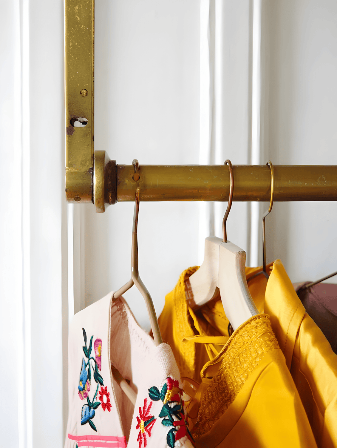Colourful second-hand garments on a golden clothing rack